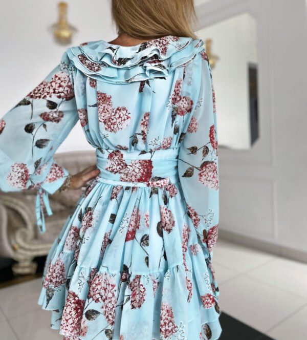 Back view of the Sophia Mint Blue Floral Mini Day Dress highlighting its layered flowy skirt, cinched waist, and detailed ruffle collar against an elegant background.