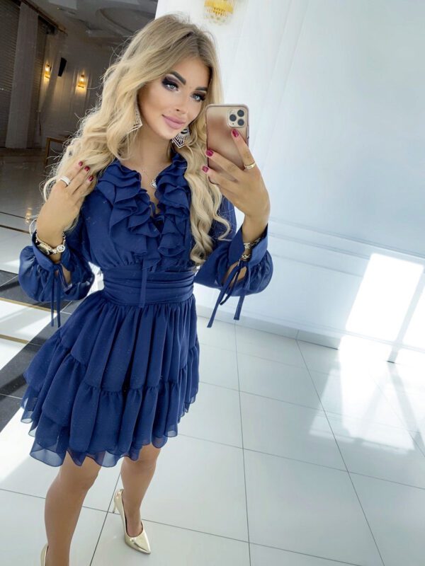 A model wearing the Sophia Navy Blue Long Sleeve Mini Party Dress, emphasizing its layered skirt and sophisticated design.